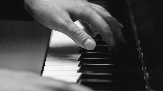 Close-up of hands playing a piano, black and white photo