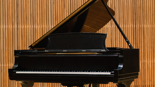 Black grand piano against a wooden paneled wall