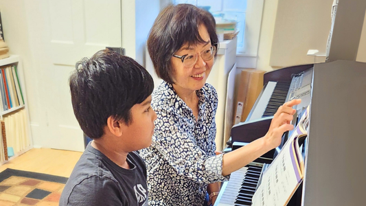 Woman teaching a child how to play the piano