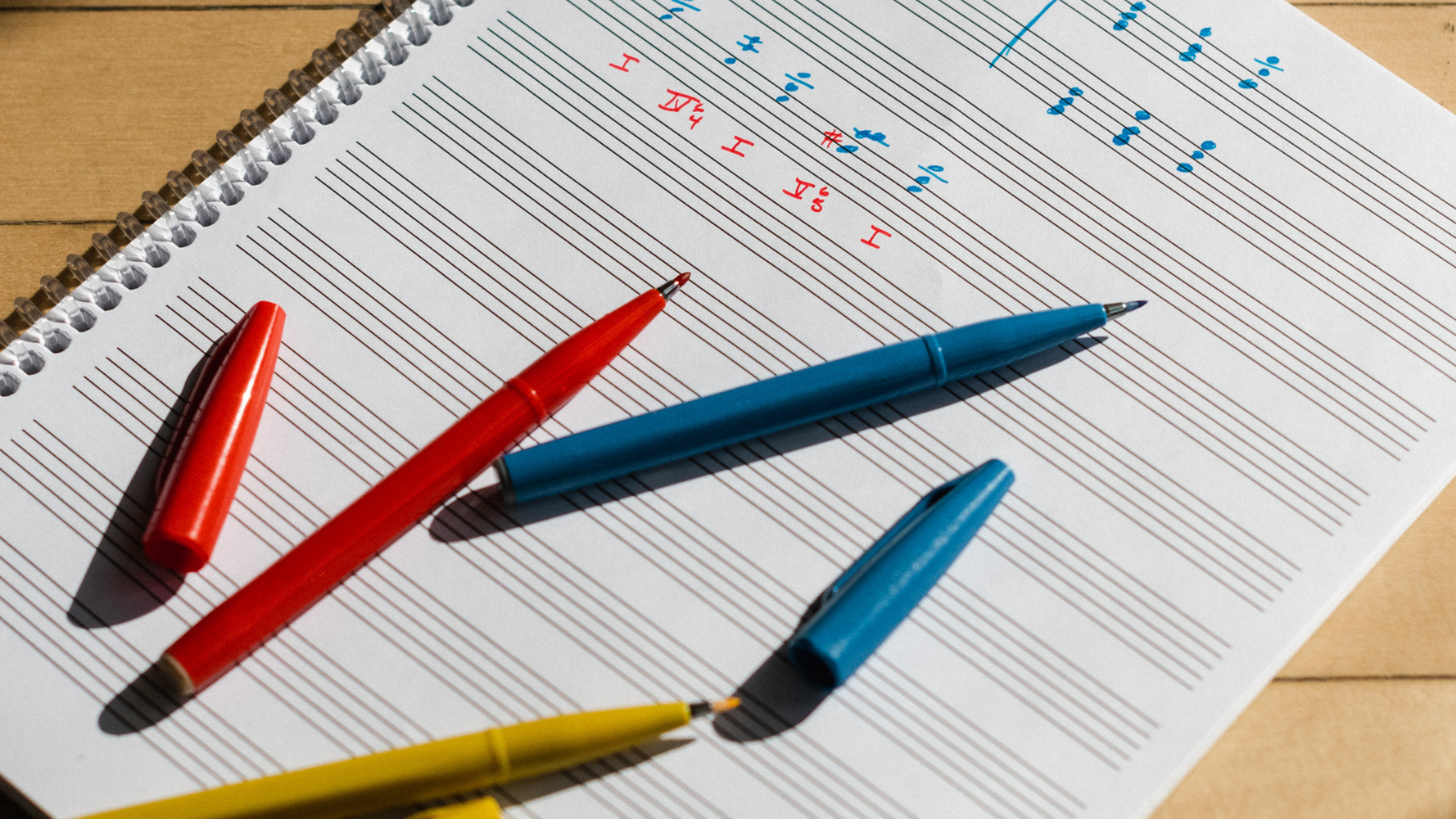 Colorful markers on a sheet of music notation paper