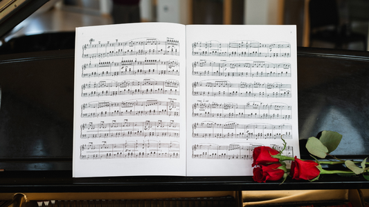 Sheet music on a piano with red roses