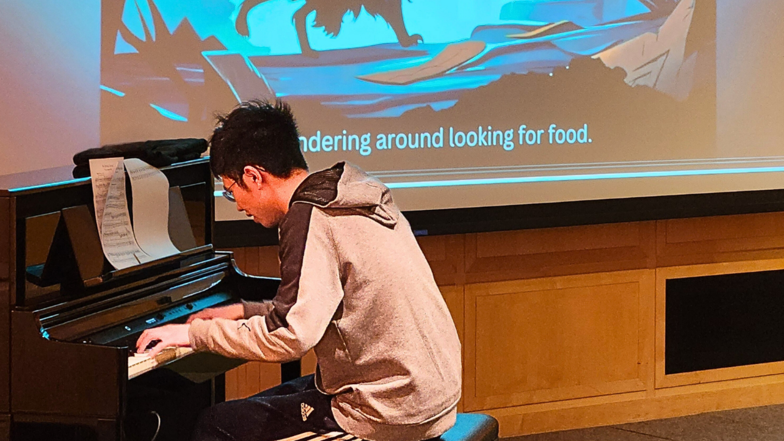 Person playing piano with a projected image in the background